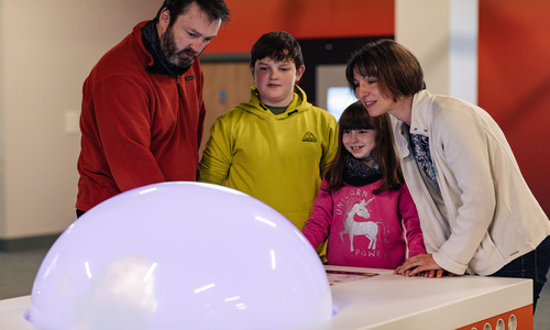 family playing with liquid storm exhibit